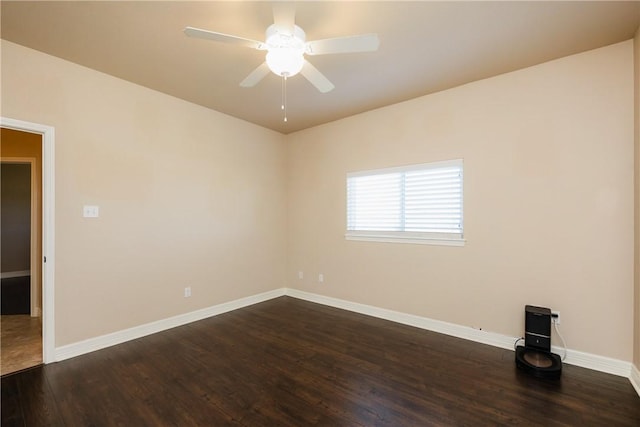 spare room with ceiling fan, dark wood-type flooring, and baseboards