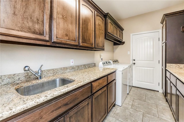 washroom featuring a sink, cabinet space, and separate washer and dryer