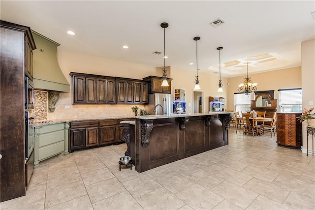 kitchen with visible vents, a breakfast bar, stainless steel appliances, decorative backsplash, and dark brown cabinetry