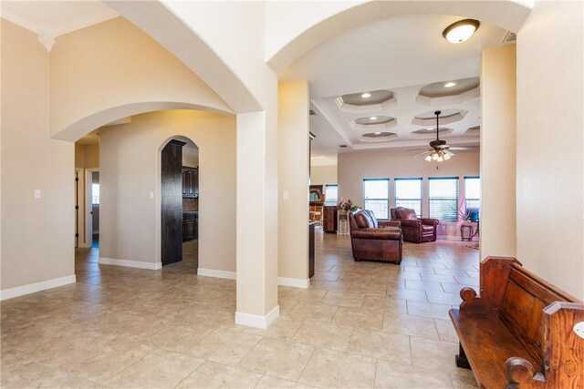 foyer with arched walkways, coffered ceiling, a high ceiling, and ceiling fan