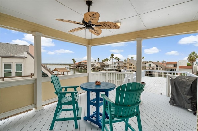 deck with a water view, a residential view, grilling area, and a ceiling fan