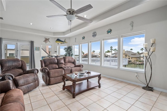 living room featuring light tile patterned floors, ceiling fan, and a healthy amount of sunlight