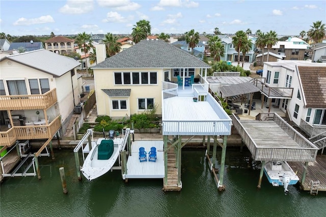 dock area featuring boat lift, a residential view, and a water view