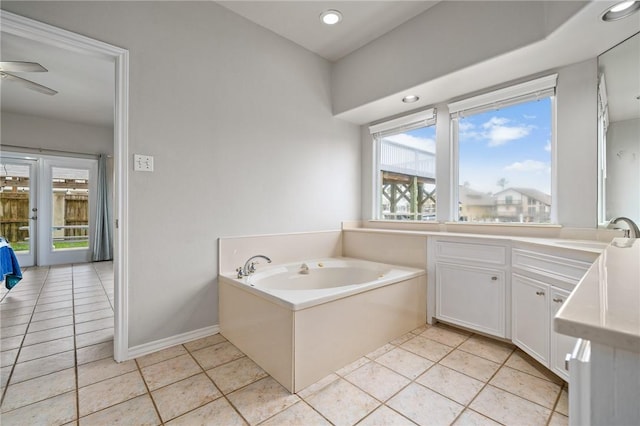 bathroom featuring vanity, baseboards, tile patterned flooring, a ceiling fan, and a garden tub
