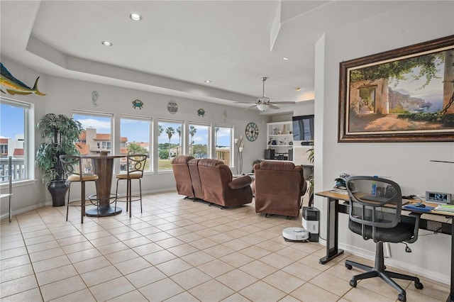 living room featuring baseboards, a raised ceiling, recessed lighting, and a ceiling fan