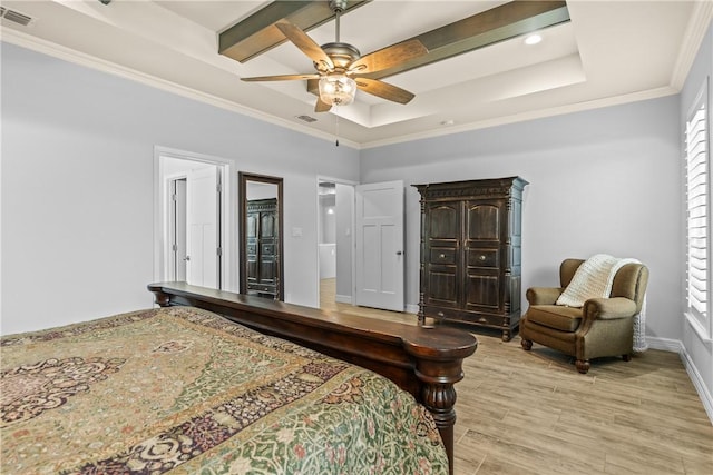 bedroom featuring light wood finished floors, visible vents, a tray ceiling, and baseboards