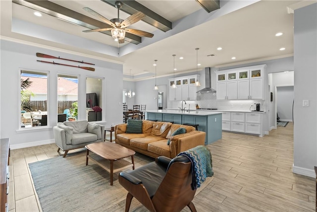 living room featuring recessed lighting, light wood finished floors, ceiling fan, and a tray ceiling