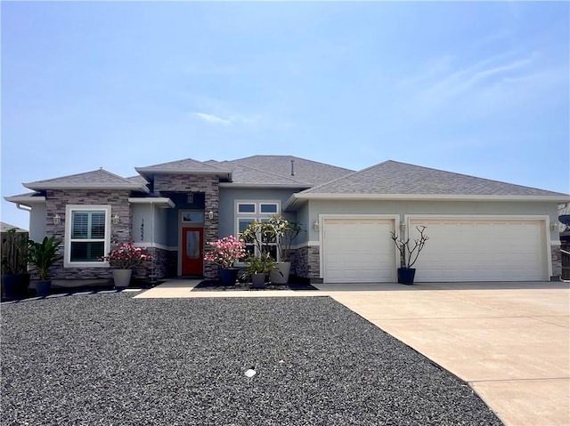 prairie-style house featuring driveway, stone siding, an attached garage, and stucco siding