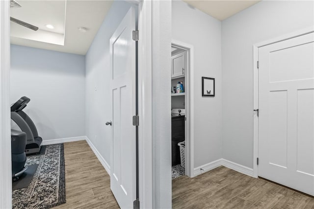 hallway featuring baseboards and wood finished floors