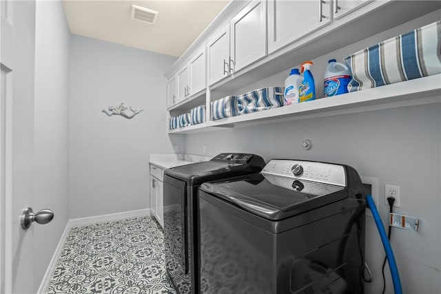 laundry room featuring cabinet space, washer and clothes dryer, tile patterned floors, visible vents, and baseboards
