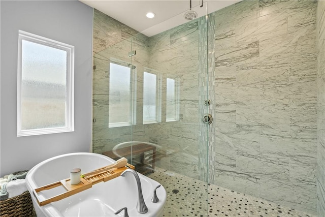full bath featuring a marble finish shower, a freestanding tub, and a healthy amount of sunlight