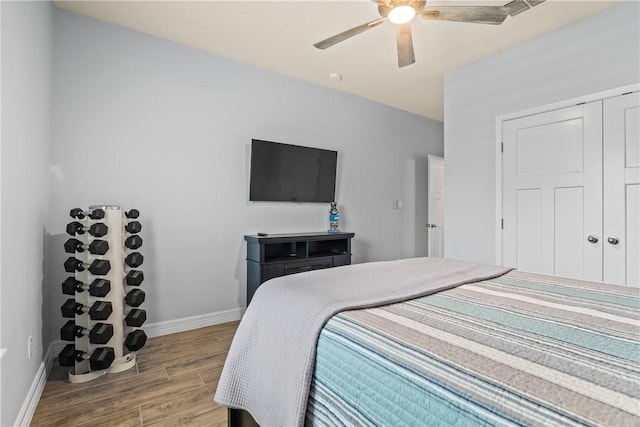 bedroom featuring a closet, ceiling fan, wood finished floors, and baseboards