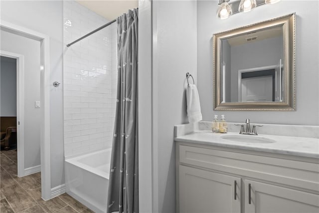 bathroom with shower / bathtub combination with curtain, vanity, and baseboards