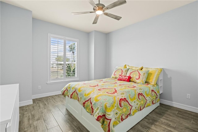 bedroom with baseboards, wood finished floors, and ceiling fan