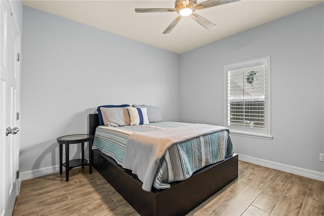 bedroom featuring wood finished floors, a ceiling fan, and baseboards