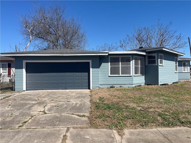 ranch-style house featuring a front lawn, concrete driveway, and an attached garage