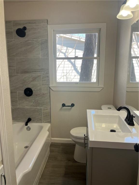 full bath featuring shower / washtub combination, toilet, vanity, wood finished floors, and baseboards