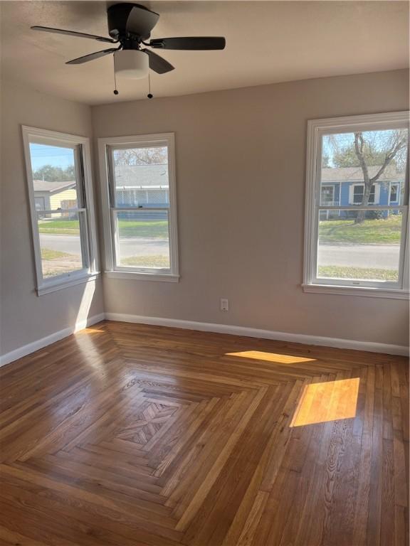 unfurnished room with a ceiling fan and baseboards