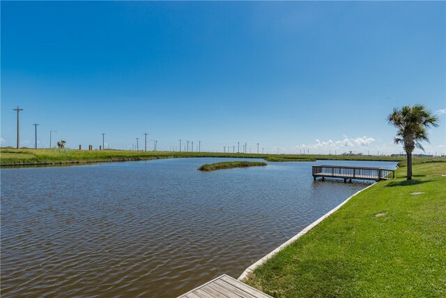 dock area with a water view and a yard