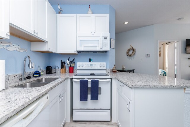 kitchen with white cabinetry, light wood-type flooring, white appliances, sink, and kitchen peninsula