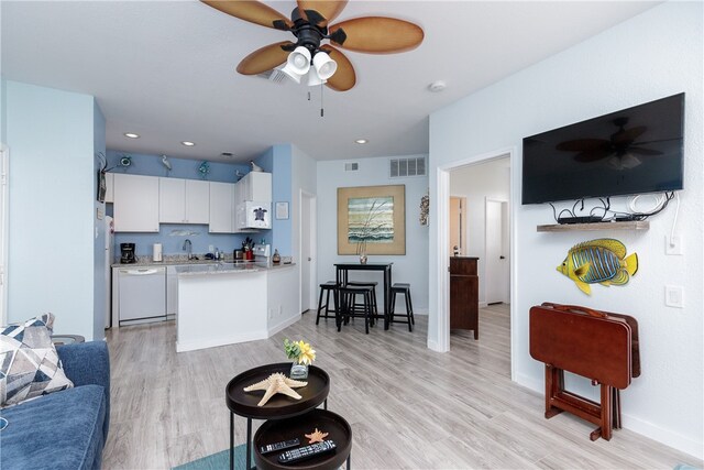 living room featuring light hardwood / wood-style floors, ceiling fan, and sink