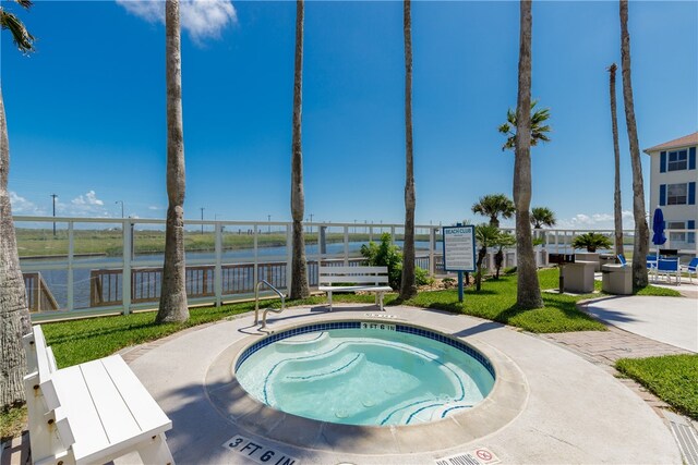 view of swimming pool with a water view, a community hot tub, and a yard