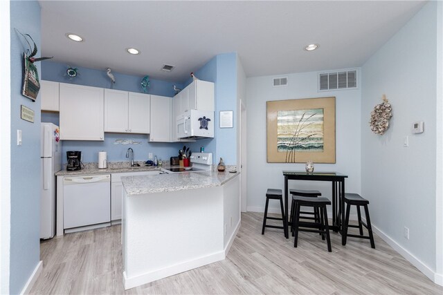 kitchen featuring white cabinets, white appliances, kitchen peninsula, and light hardwood / wood-style floors