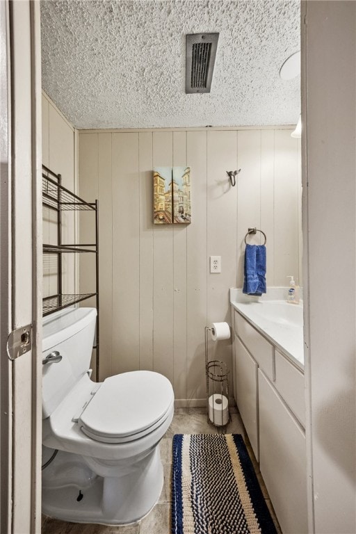 14300 S Padre Island Dr Unit 93, Corpus Christi, TX 78418 - bathroom with toilet, vanity, a textured ceiling, and a decorative wall