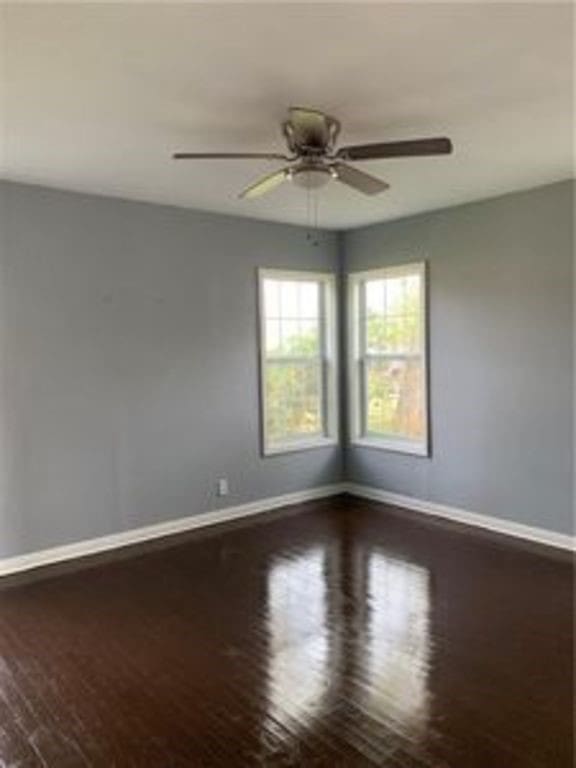 unfurnished room with baseboards and wood finished floors