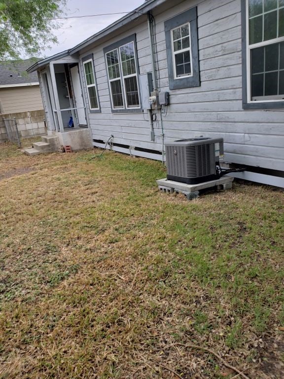 back of house with a yard and cooling unit