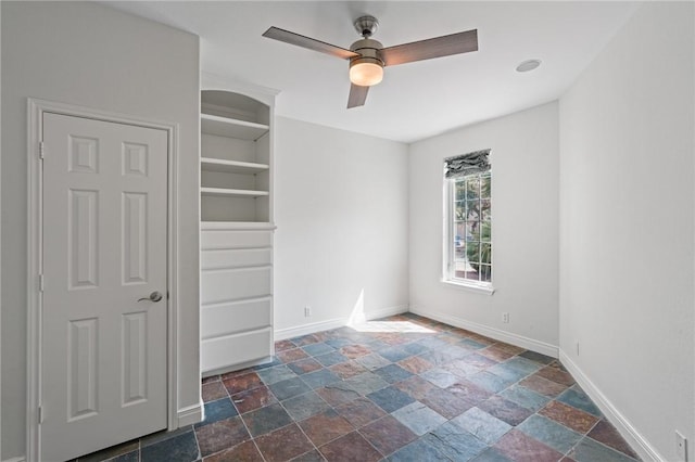 10 Kingfisher Ln, Rockport, TX 78382 - unfurnished bedroom with dark stone finish flooring and ceiling fan