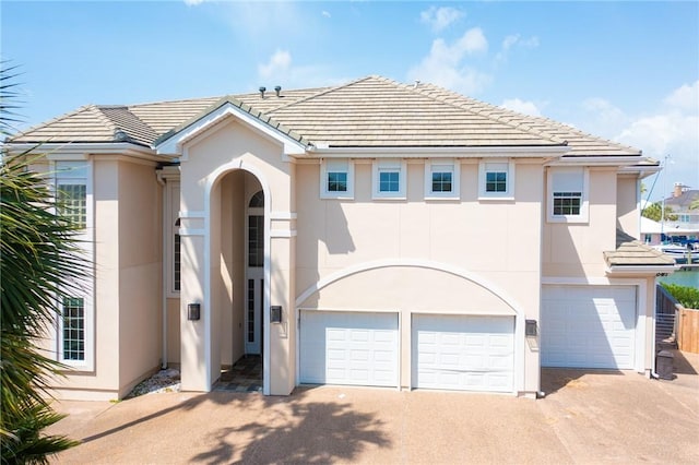 10 Kingfisher Ln, Rockport, TX 78382 - view of front facade featuring stucco siding, an attached garage, concrete driveway, and a tiled roof