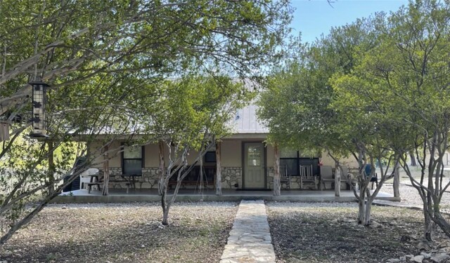 197 N Tomahawk Way, Concan, TX 78838 - view of property hidden behind natural elements with covered porch, stucco siding, and stone siding