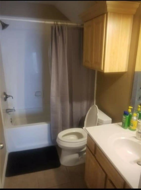 full bathroom featuring tile patterned flooring, vanity, toilet, and shower / tub combo with curtain