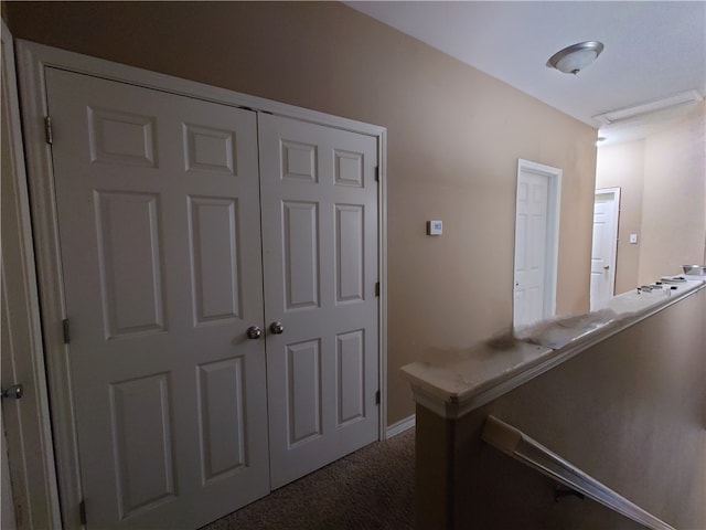 corridor featuring dark colored carpet