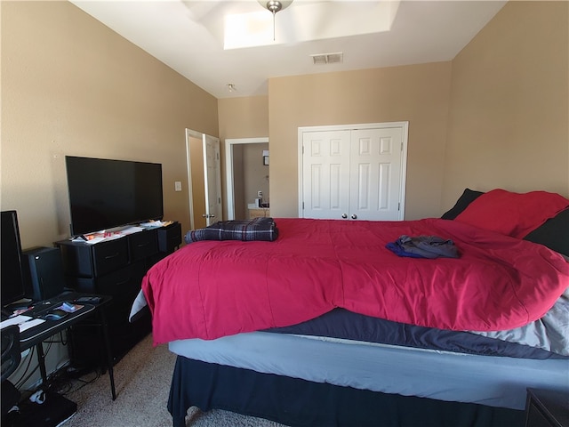 carpeted bedroom with lofted ceiling and a closet