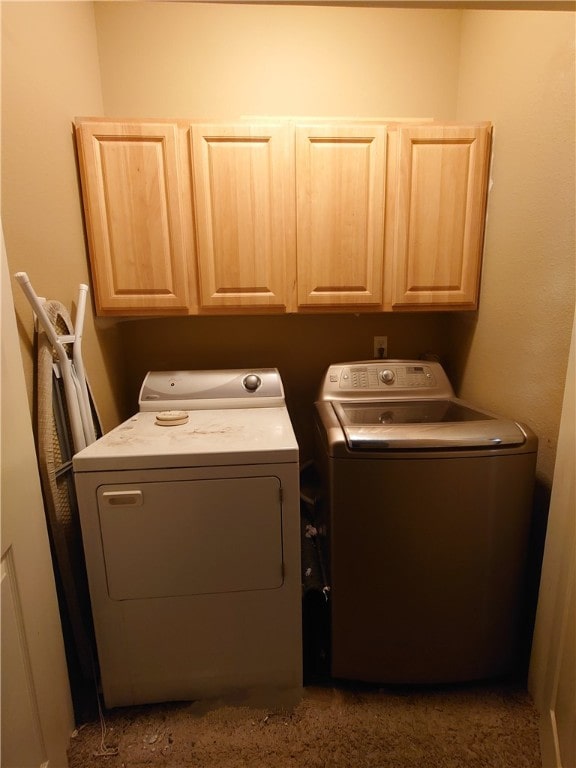 laundry room featuring washer and clothes dryer and cabinets