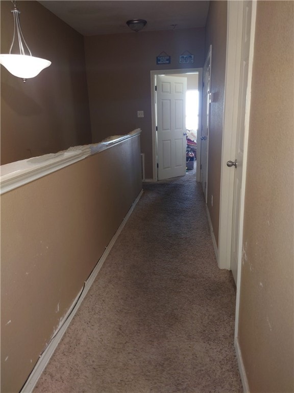 hallway featuring dark colored carpet