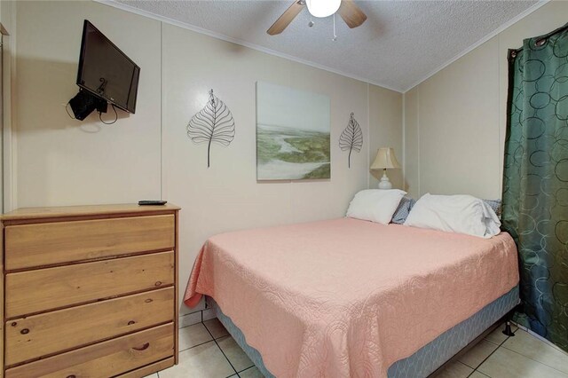 3938 Surfside Blvd Unit 3114, Corpus Christi, TX 78402 - bedroom featuring ornamental molding, light tile patterned floors, a textured ceiling, and a ceiling fan