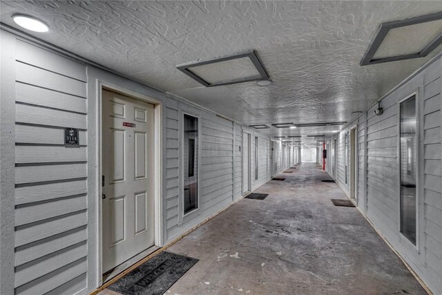 3938 Surfside Blvd Unit 3114, Corpus Christi, TX 78402 - hallway featuring attic access, concrete floors, and a textured ceiling