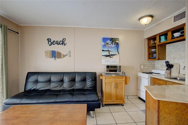 3938 Surfside Blvd Unit 3114, Corpus Christi, TX 78402 - kitchen featuring white stove, light tile patterned floors, crown molding, backsplash, and light countertops