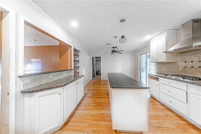 445 Troy Dr, Corpus Christi, TX 78412 - kitchen featuring wall chimney range hood, a center island, a ceiling fan, a textured ceiling, and decorative backsplash