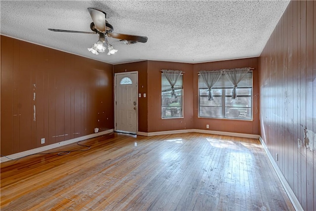 445 Troy Dr, Corpus Christi, TX 78412 - foyer featuring ceiling fan, hardwood / wood-style floors, a textured ceiling, wood walls, and baseboards