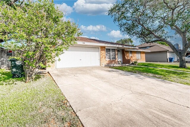 445 Troy Dr, Corpus Christi, TX 78412 - ranch-style house with an attached garage, concrete driveway, brick siding, and a front lawn