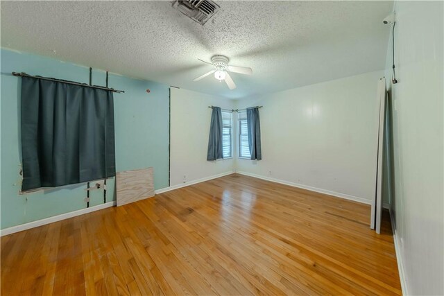 445 Troy Dr, Corpus Christi, TX 78412 - spare room with a textured ceiling, ceiling fan, light wood-style flooring, and baseboards