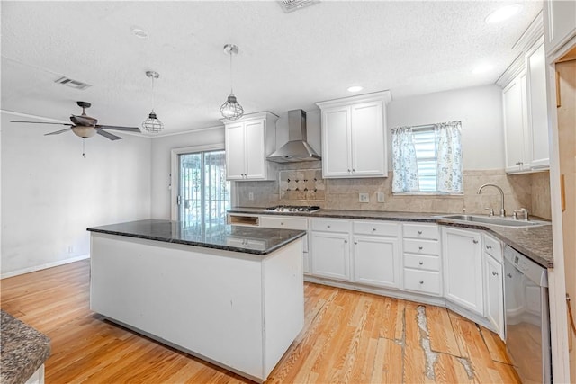 445 Troy Dr, Corpus Christi, TX 78412 - kitchen with wall chimney exhaust hood, stainless steel appliances, a sink, light wood-style flooring, and a textured ceiling