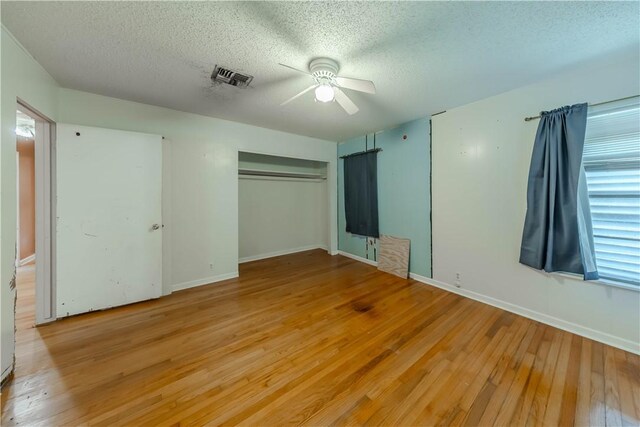 445 Troy Dr, Corpus Christi, TX 78412 - unfurnished bedroom with a textured ceiling, light wood-style flooring, baseboards, ceiling fan, and a closet