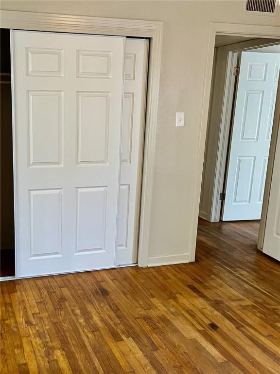4225 Lowman St, Corpus Christi, TX 78411 - unfurnished bedroom with a closet, baseboards, and wood finished floors