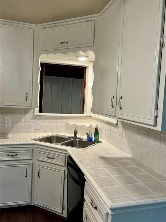 4225 Lowman St, Corpus Christi, TX 78411 - kitchen with a sink, black dishwasher, tasteful backsplash, and white cabinetry