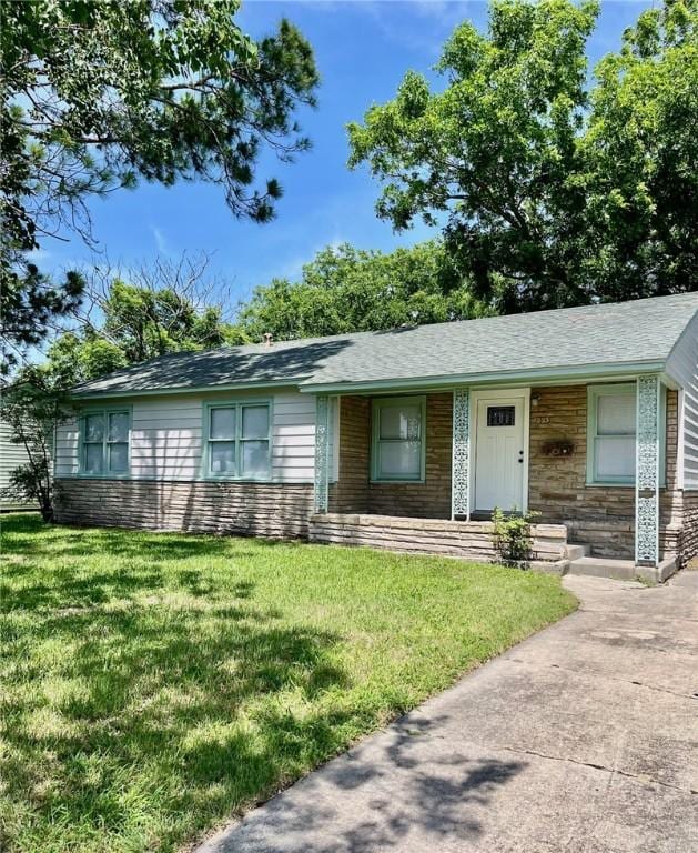 4225 Lowman St, Corpus Christi, TX 78411 - ranch-style home with a front yard, stone siding, and a shingled roof